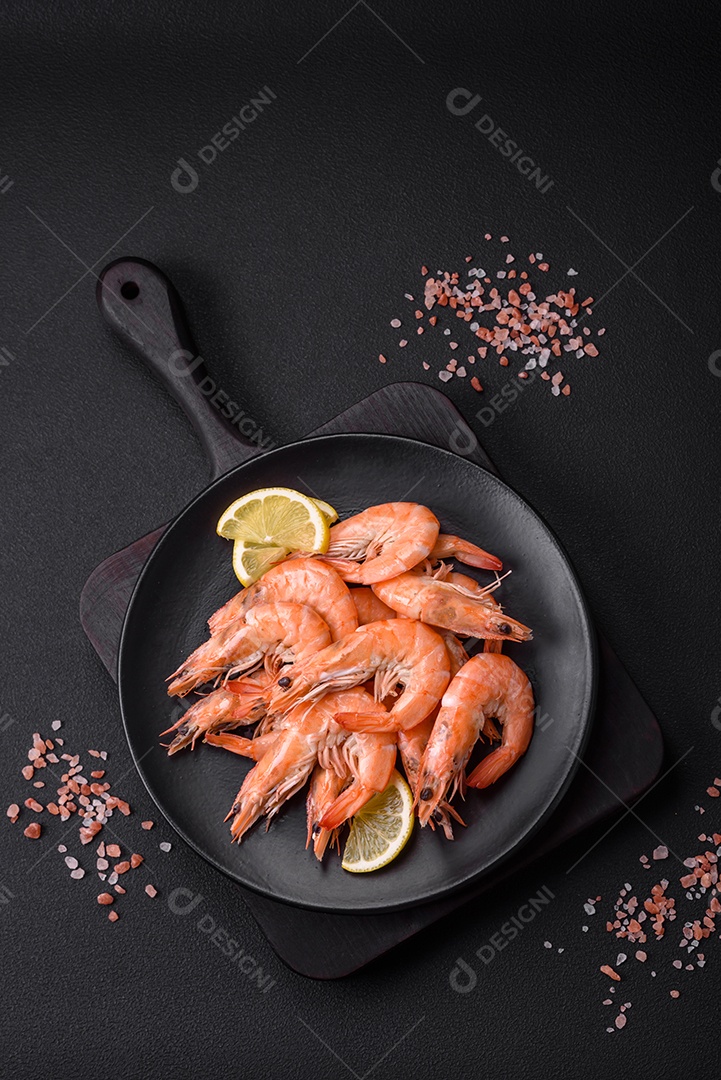 Camarão tigre ou lagostim fervido com especiarias e sal sobre um fundo escuro de concreto
