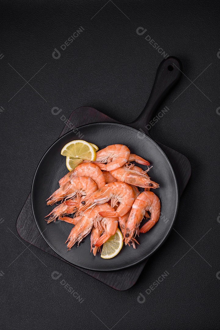 Camarão tigre ou lagostim fervido com especiarias e sal sobre um fundo escuro de concreto