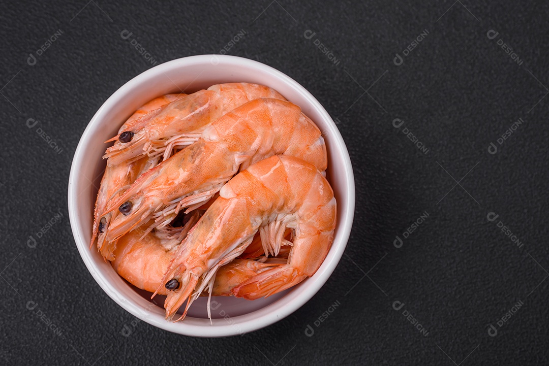Camarão tigre ou lagostim fervido com especiarias e sal sobre um fundo escuro de concreto