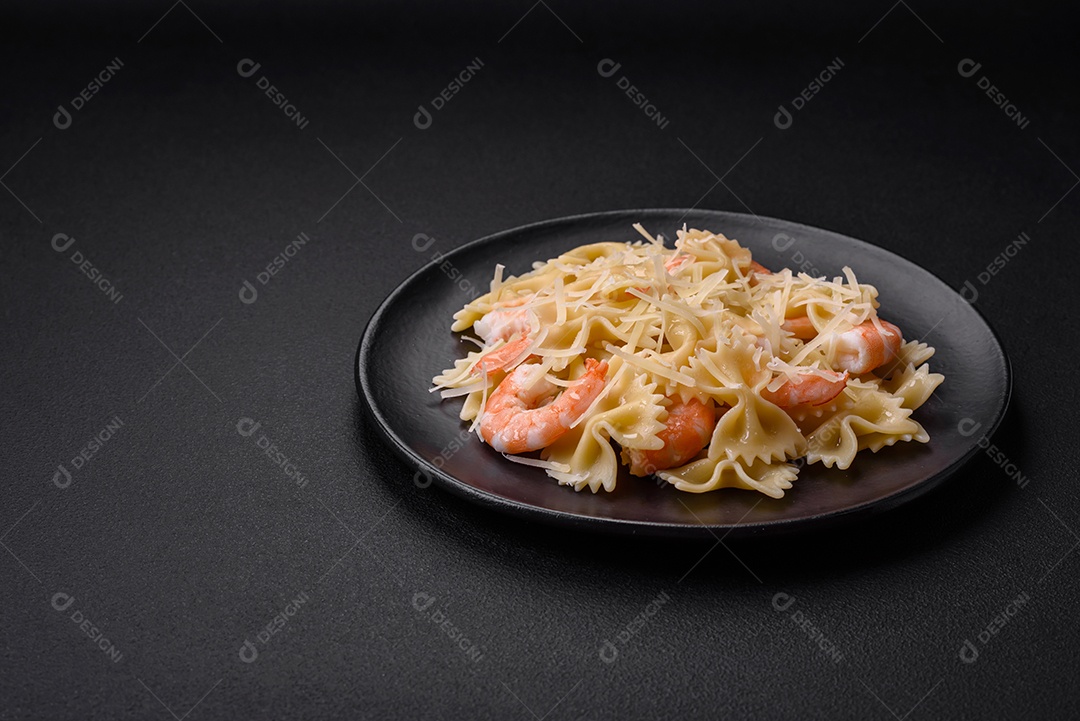 Deliciosa massa farfalle com camarão lagostim com molho cremoso e queijo sobre fundo escuro de concreto