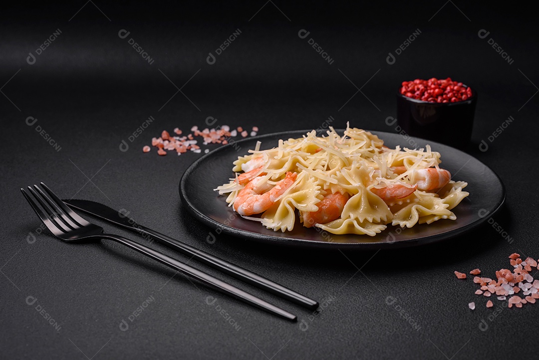 Deliciosa massa farfalle com camarão lagostim com molho cremoso e queijo sobre fundo escuro de concreto