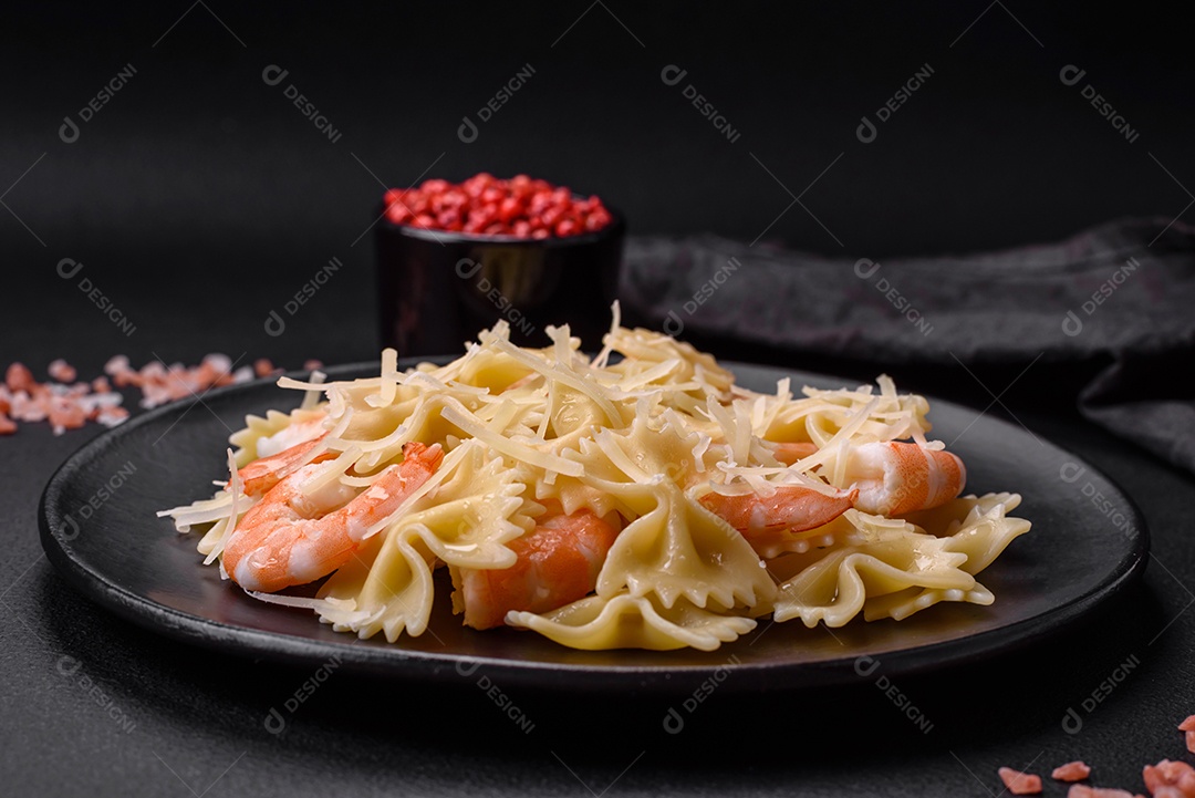 Deliciosa massa farfalle com camarão lagostim com molho cremoso e queijo sobre fundo escuro de concreto