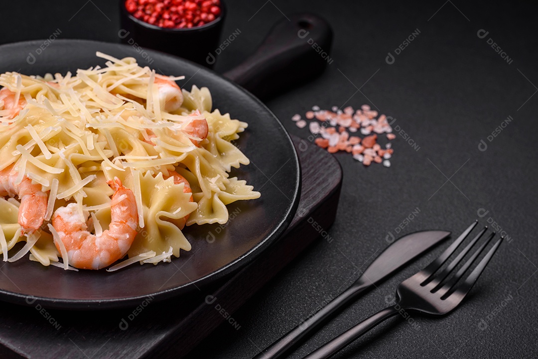 Deliciosa massa farfalle com camarão lagostim com molho cremoso e queijo sobre fundo escuro de concreto