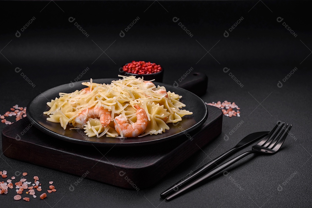 Deliciosa massa farfalle com camarão lagostim com molho cremoso e queijo sobre fundo escuro de concreto