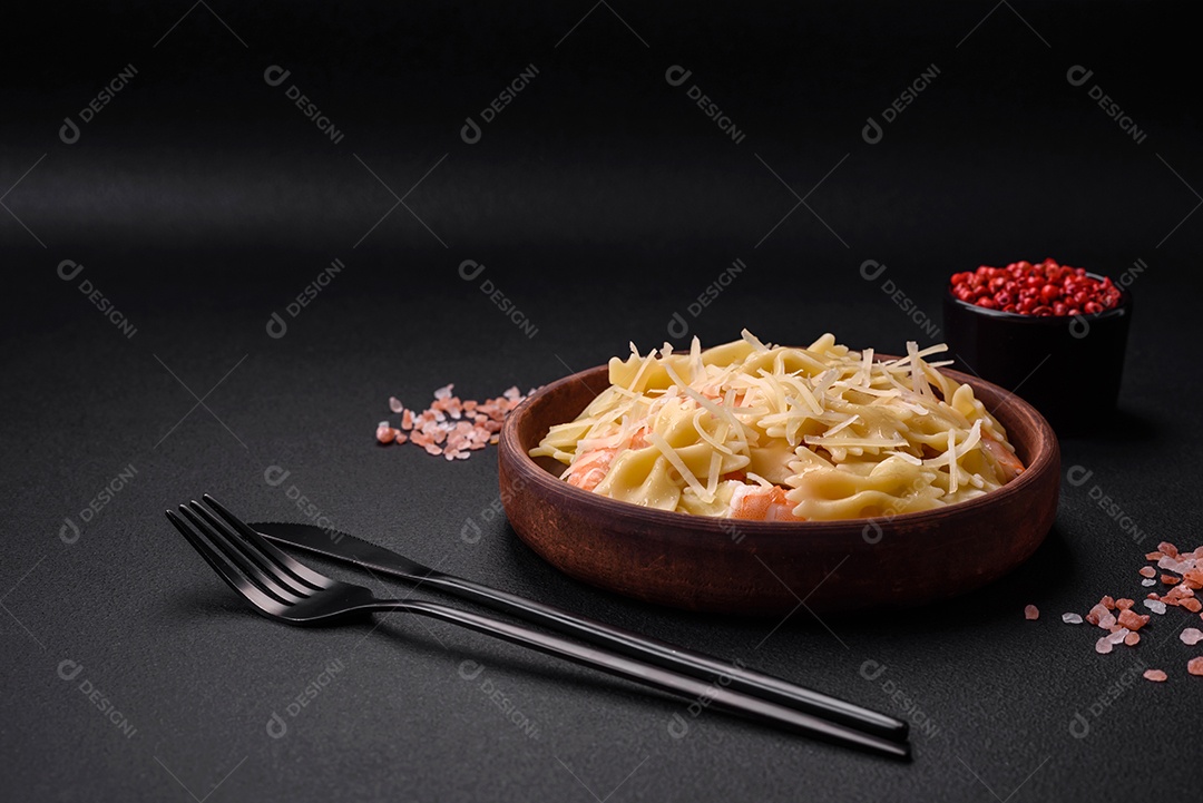 Deliciosa massa farfalle com camarão lagostim com molho cremoso e queijo sobre fundo escuro de concreto