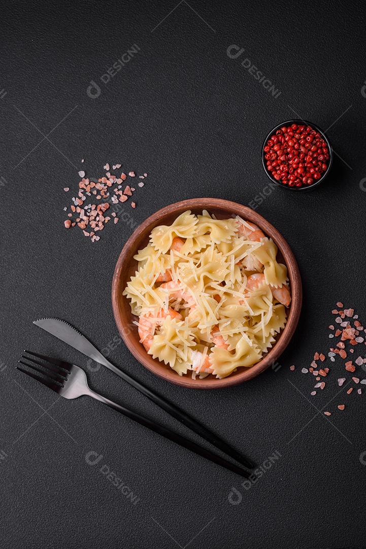 Deliciosa massa farfalle com camarão lagostim com molho cremoso e queijo sobre fundo escuro de concreto