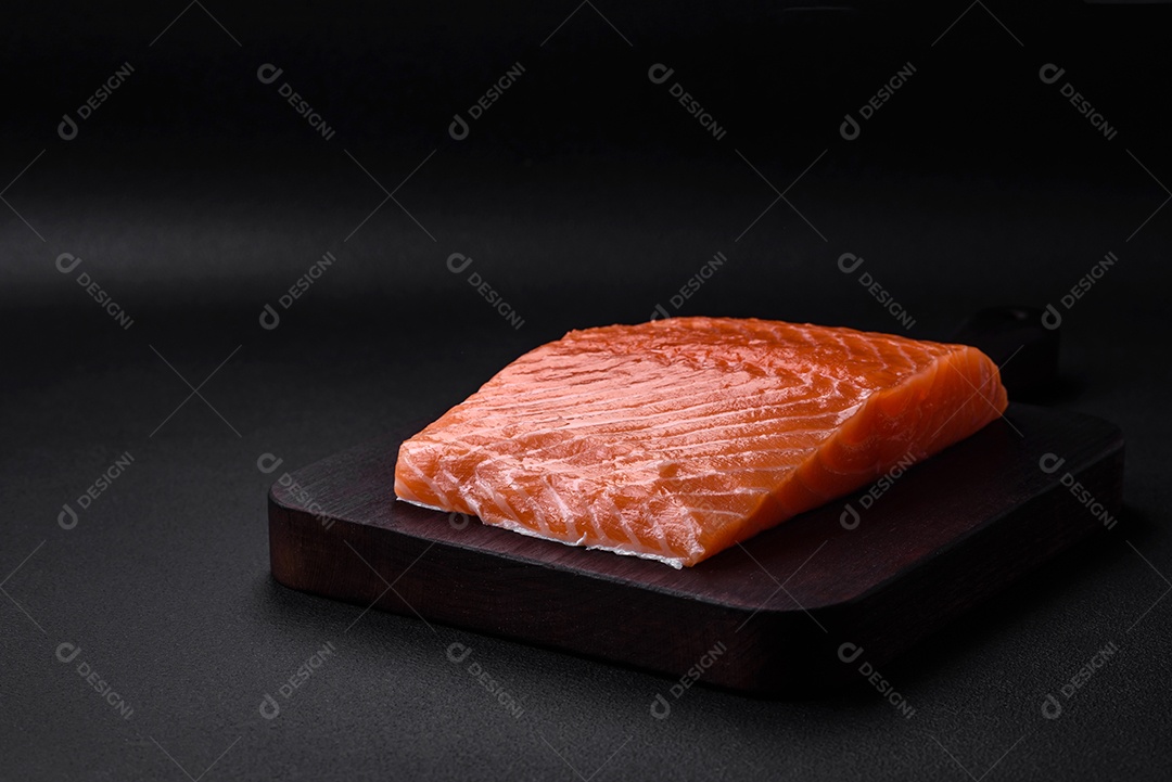 Filé de peixe vermelho fresco e saboroso com especiarias e ervas sobre um fundo escuro de concreto