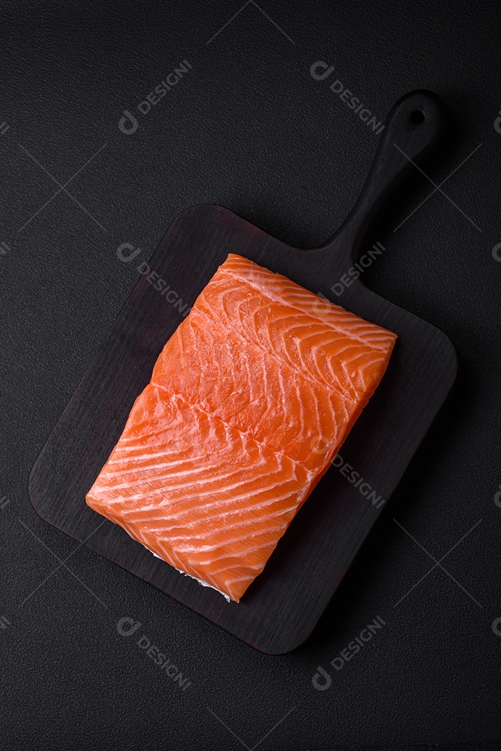 Filé de peixe vermelho fresco e saboroso com especiarias e ervas sobre um fundo escuro de concreto