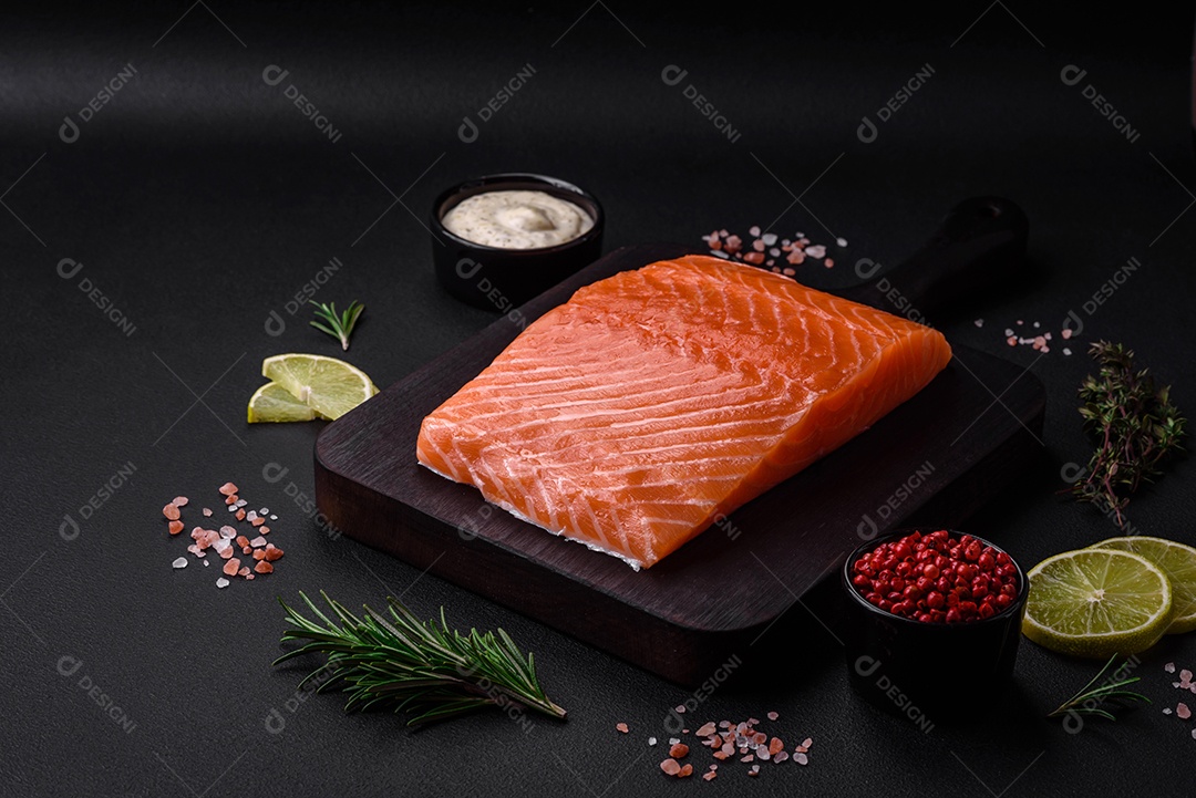 Filé de peixe vermelho fresco e saboroso com especiarias e ervas sobre um fundo escuro de concreto