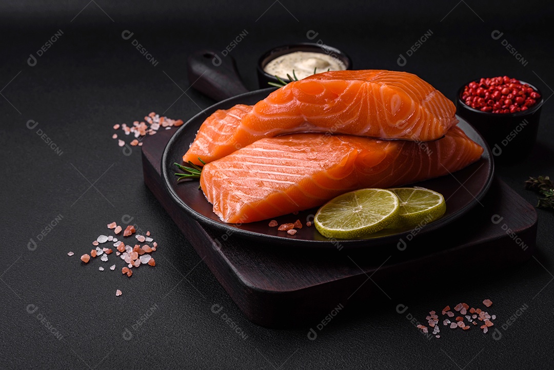 Filé de peixe vermelho fresco e saboroso com especiarias e ervas sobre um fundo escuro de concreto