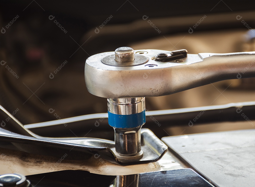Chave de soquete apertando uma porca são usadas em reparos de automóveis em oficinas