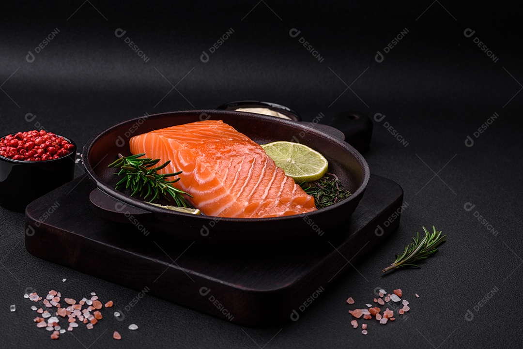 Filé de peixe vermelho fresco e saboroso com especiarias e ervas sobre um fundo escuro de concreto