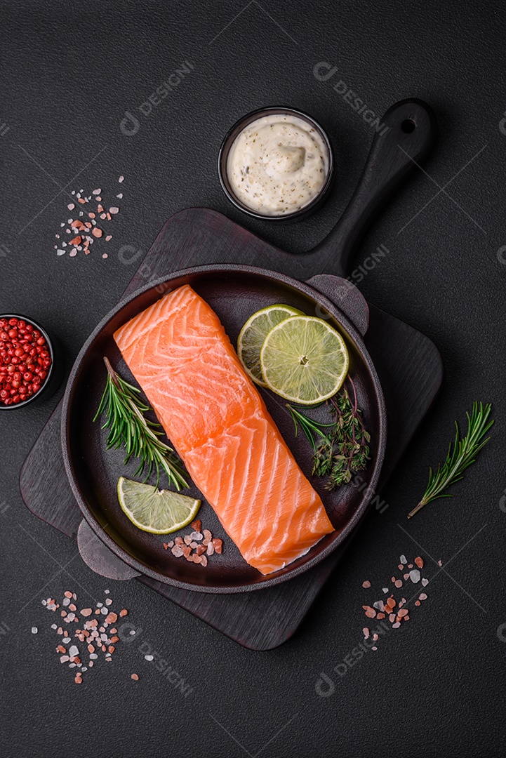 Filé de peixe vermelho fresco e saboroso com especiarias e ervas sobre um fundo escuro de concreto