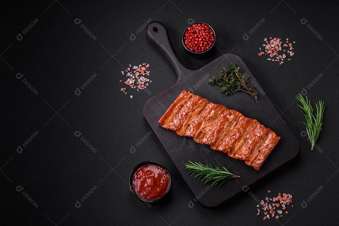 Deliciosas costelas frescas grelhadas ou defumadas com sal, especiarias e ervas em fundo escuro de concreto