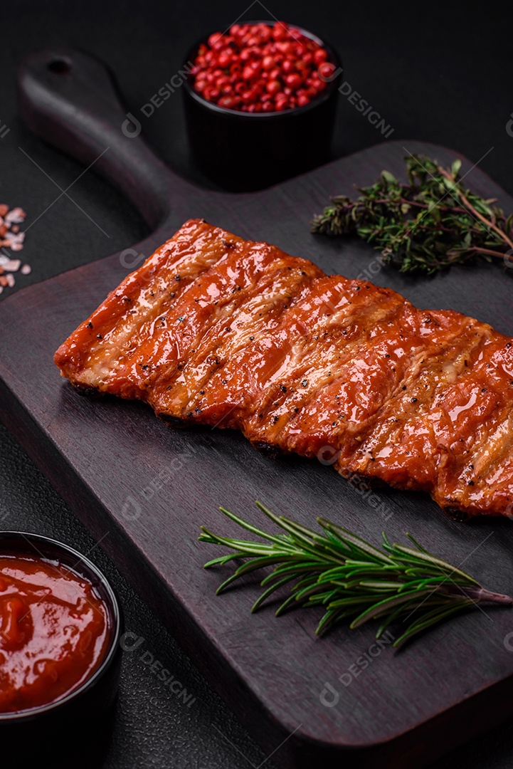 Deliciosas costelas frescas grelhadas ou defumadas com sal, especiarias e ervas em fundo escuro de concreto
