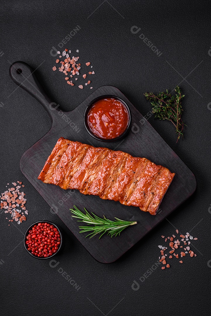 Deliciosas costelas frescas grelhadas ou defumadas com sal, especiarias e ervas em fundo escuro de concreto