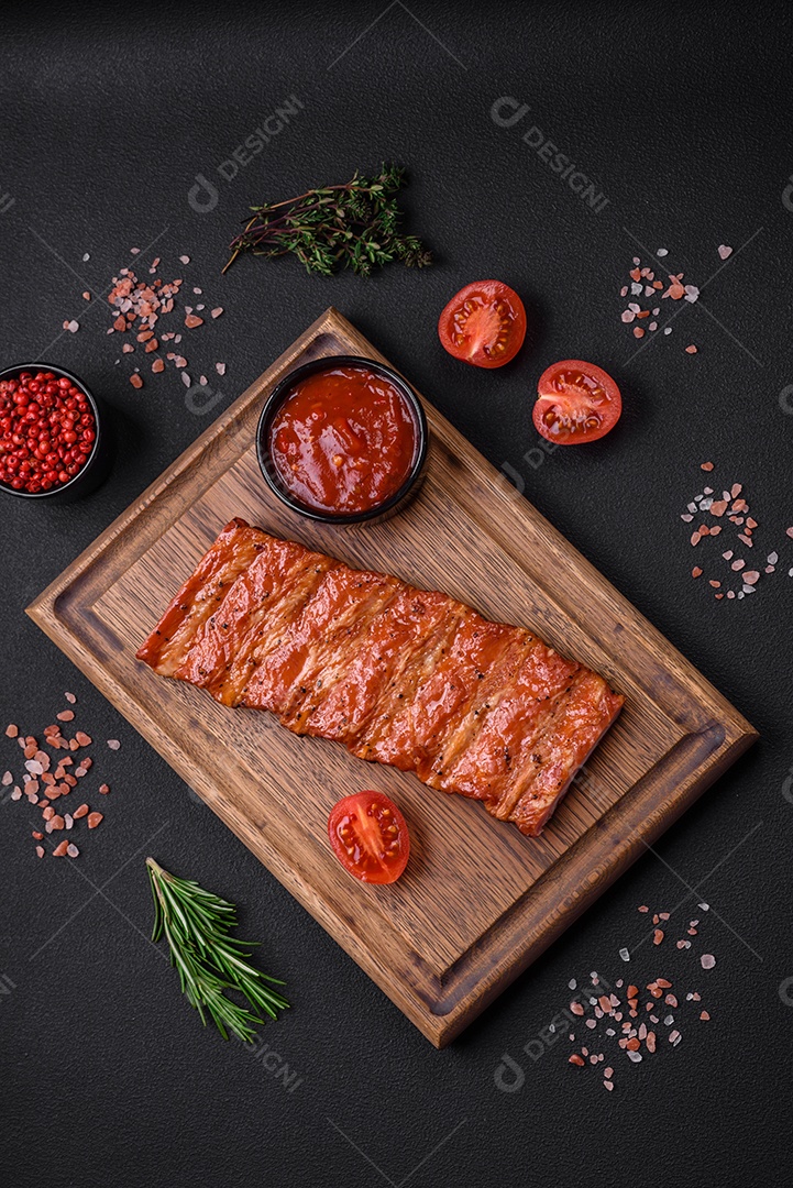 Deliciosas costelas frescas grelhadas ou defumadas com sal, especiarias e ervas em fundo escuro de concreto