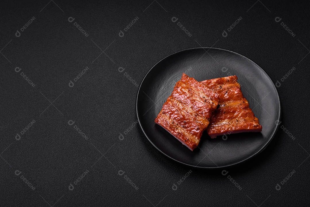 Deliciosas costelas frescas grelhadas ou defumadas com sal, especiarias e ervas em fundo escuro de concreto