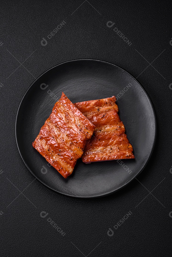 Deliciosas costelas frescas grelhadas ou defumadas com sal, especiarias e ervas em fundo escuro de concreto