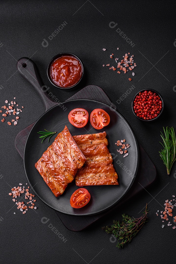 Deliciosas costelas frescas grelhadas ou defumadas com sal, especiarias e ervas em fundo escuro de concreto