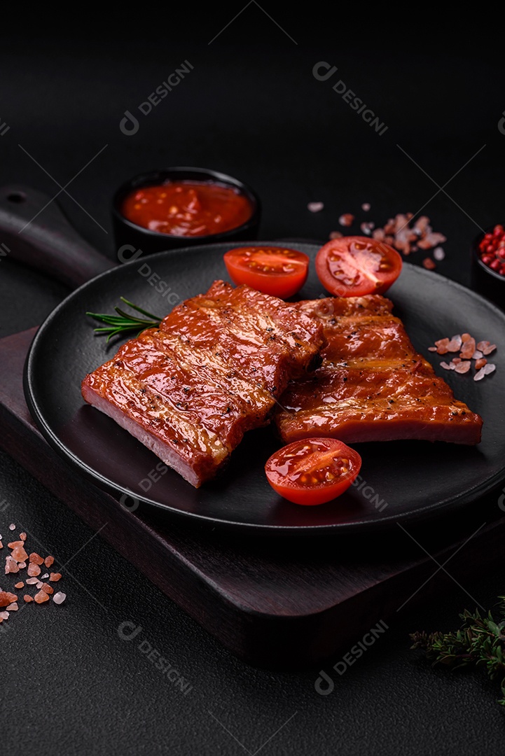 Deliciosas costelas frescas grelhadas ou defumadas com sal, especiarias e ervas em fundo escuro de concreto