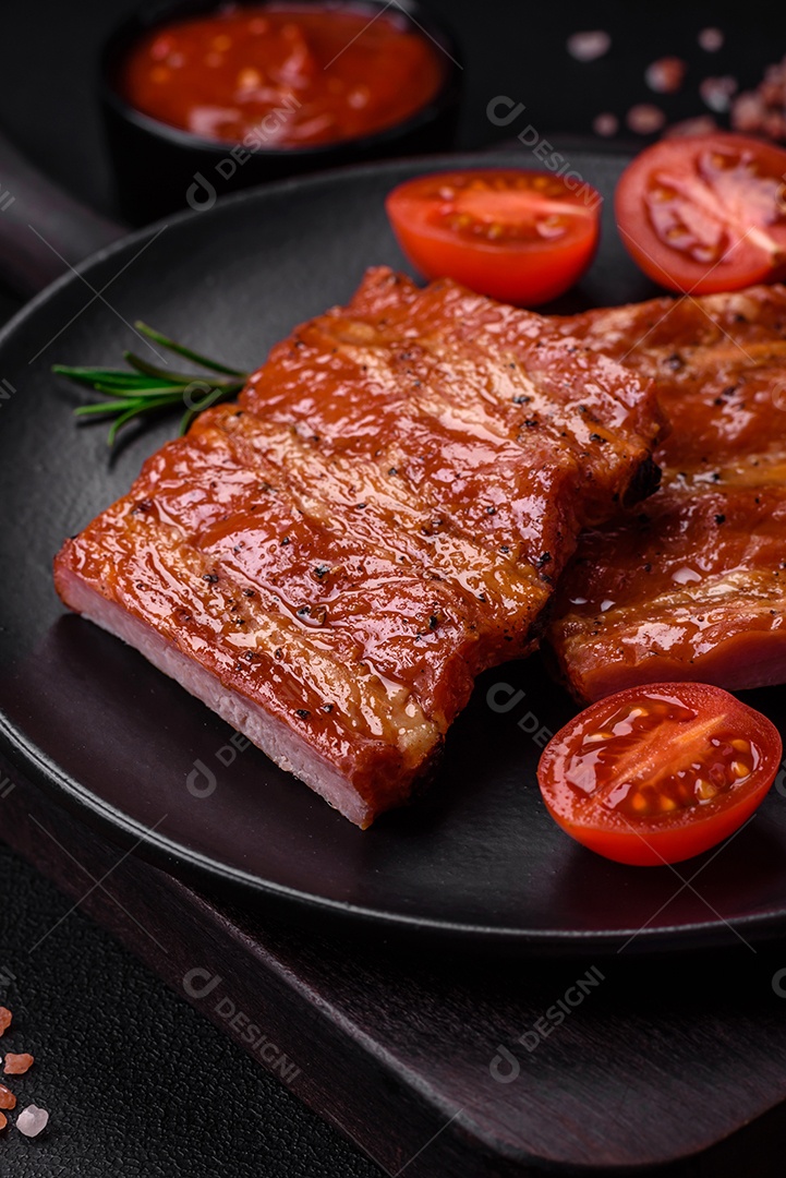 Deliciosas costelas frescas grelhadas ou defumadas com sal, especiarias e ervas em fundo escuro de concreto