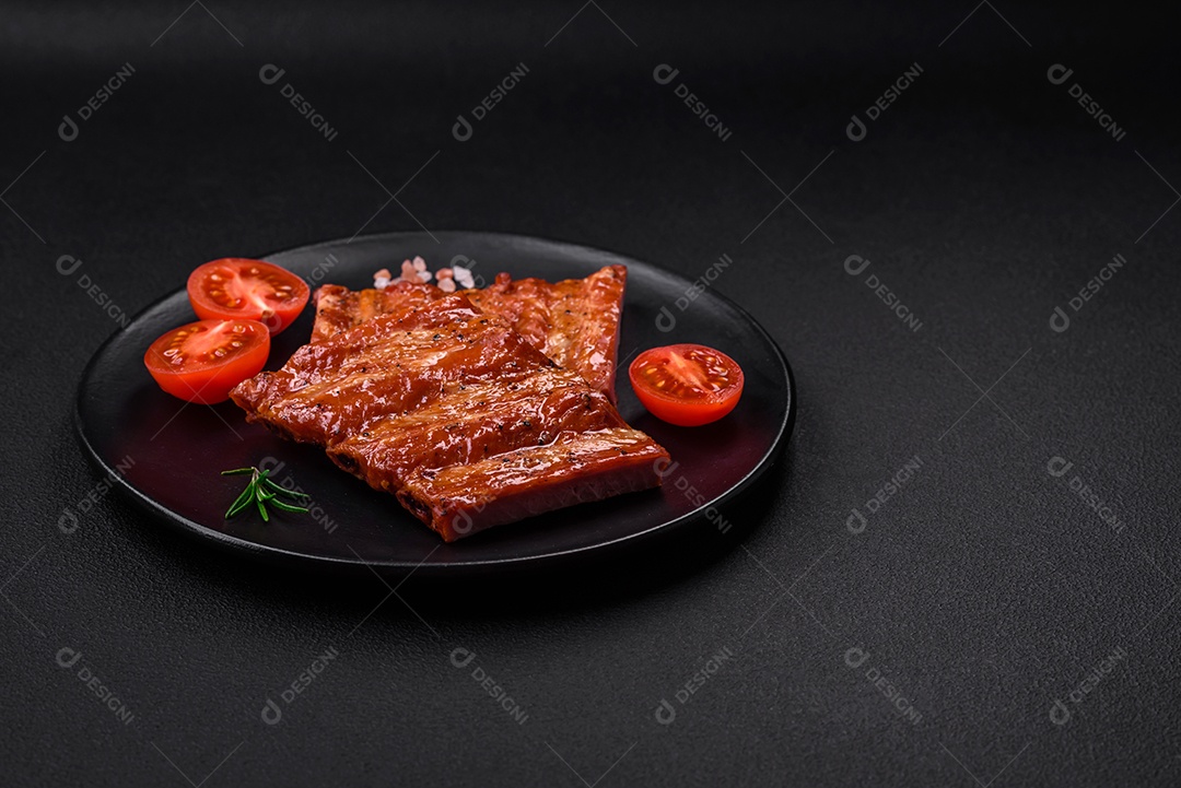 Deliciosas costelas frescas grelhadas ou defumadas com sal, especiarias e ervas em fundo escuro de concreto