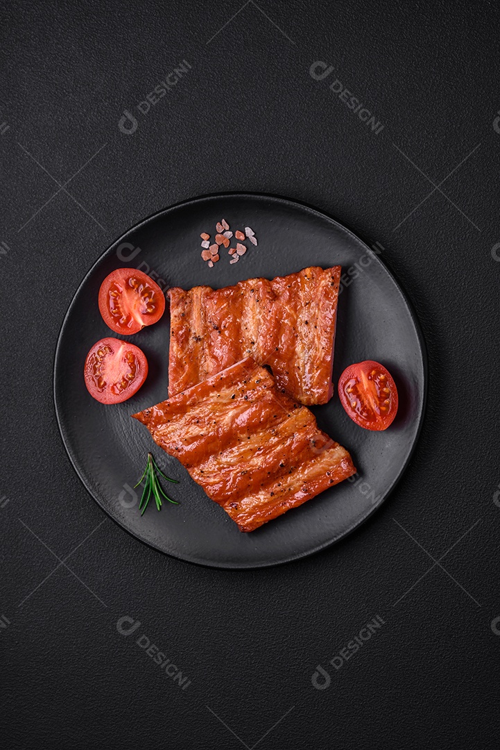 Deliciosas costelas frescas grelhadas ou defumadas com sal, especiarias e ervas em fundo escuro de concreto