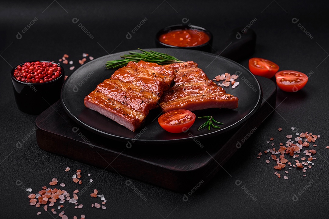 Deliciosas costelas frescas grelhadas ou defumadas com sal, especiarias e ervas em fundo escuro de concreto