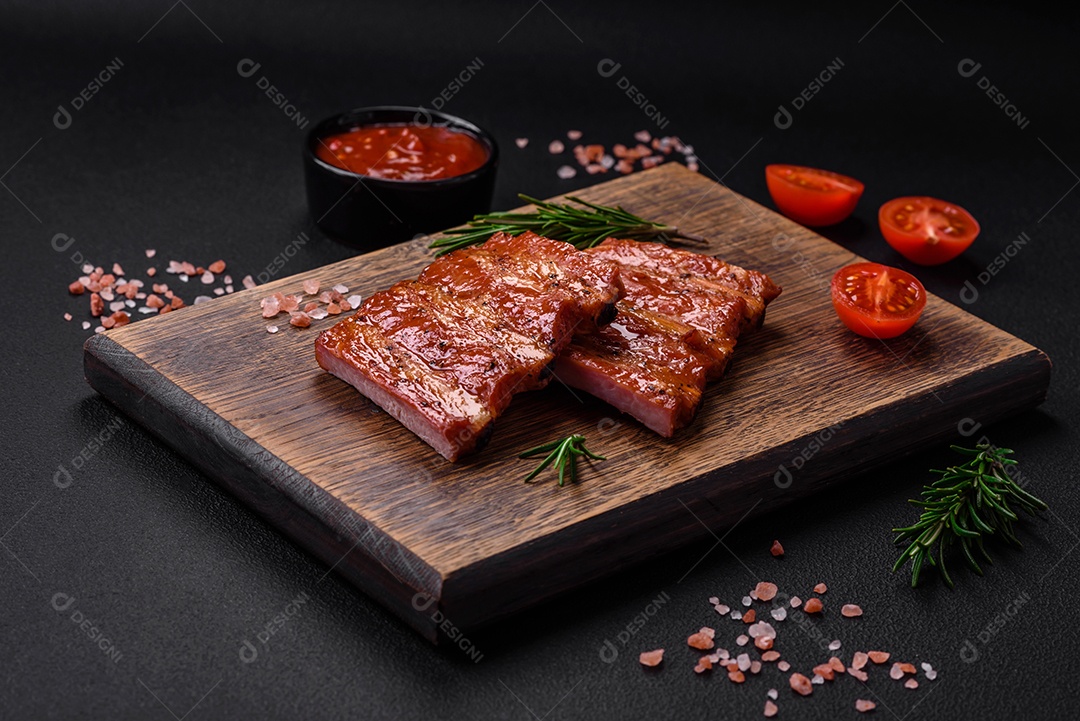 Deliciosas costelas frescas grelhadas ou defumadas com sal, especiarias e ervas em fundo escuro de concreto