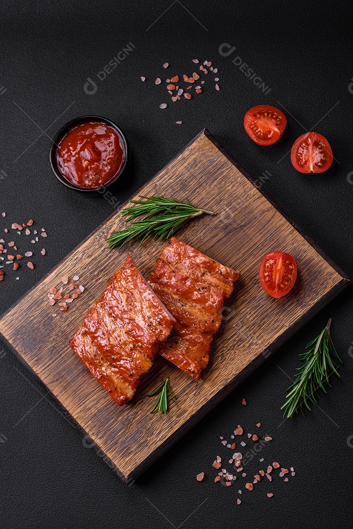 Deliciosas costelas frescas grelhadas ou defumadas com sal, especiarias e ervas em fundo escuro de concreto