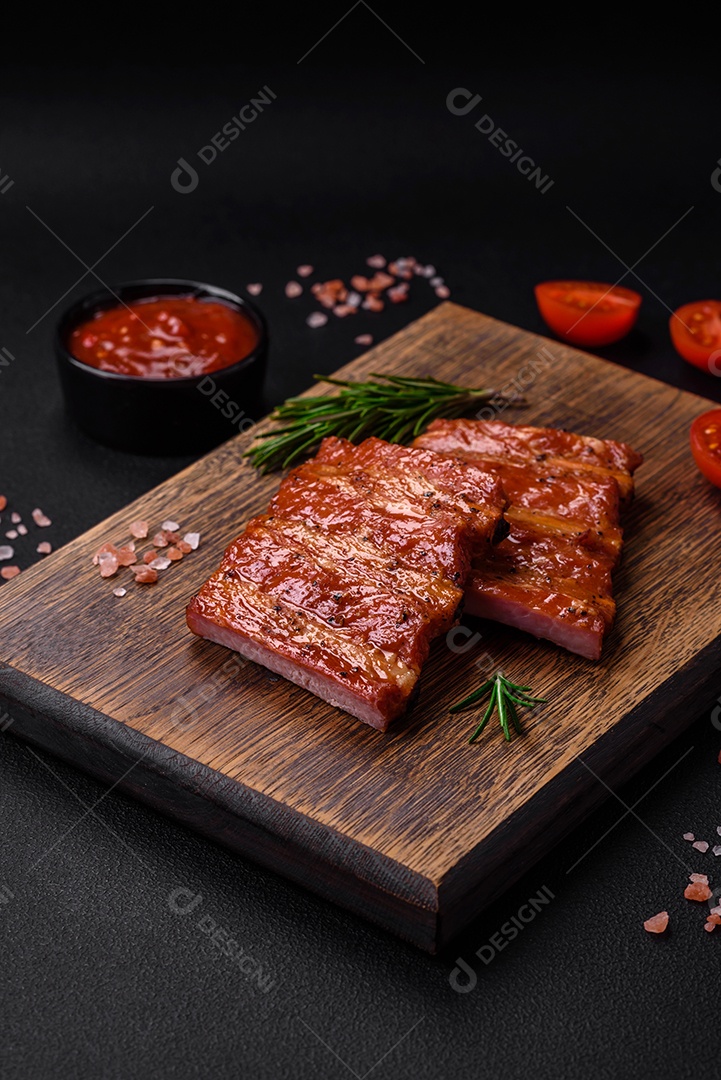 Deliciosas costelas frescas grelhadas ou defumadas com sal, especiarias e ervas em fundo escuro de concreto