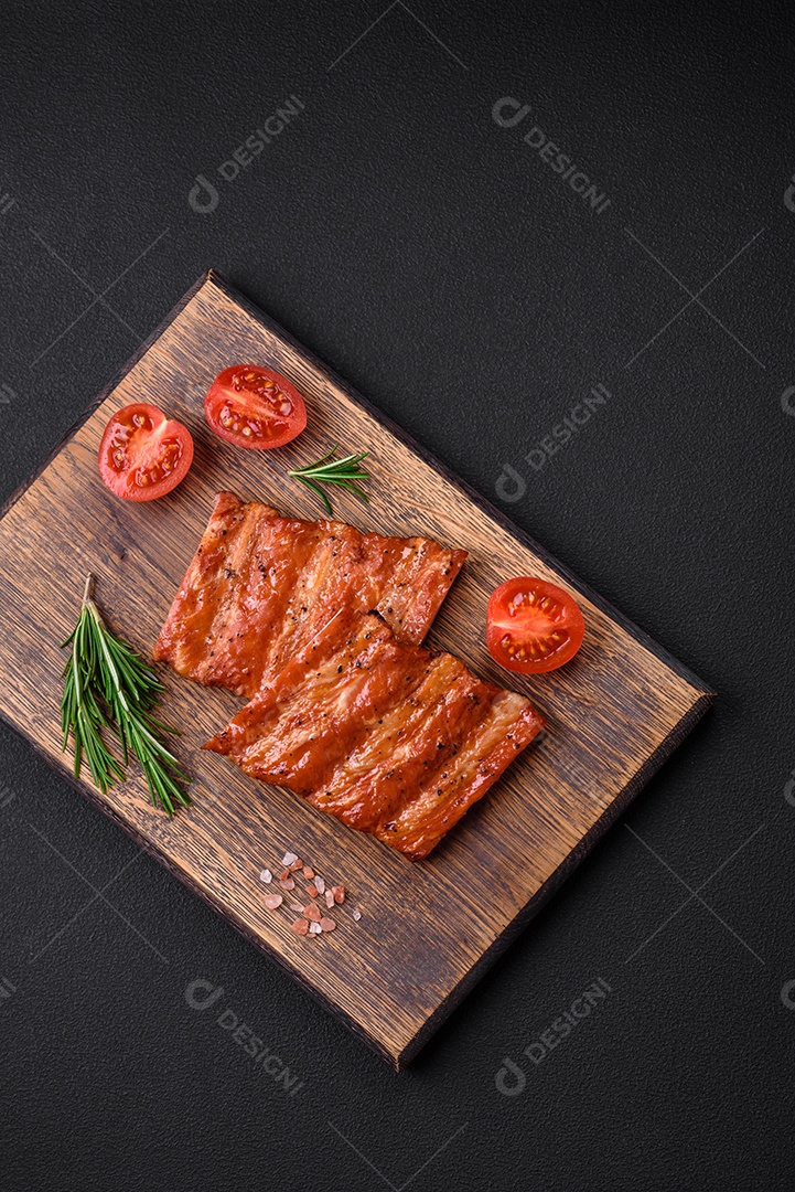 Deliciosas costelas frescas grelhadas ou defumadas com sal, especiarias e ervas em fundo escuro de concreto