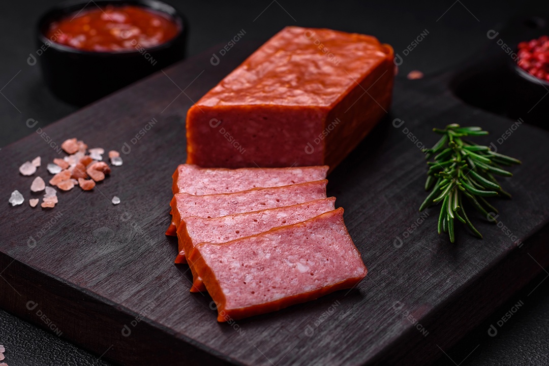 Delicioso salame de salsicha fresca com sal, tomate e especiarias sobre um fundo escuro de concreto