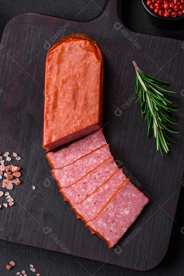 Delicioso salame de salsicha fresca com sal, tomate e especiarias sobre um fundo escuro de concreto