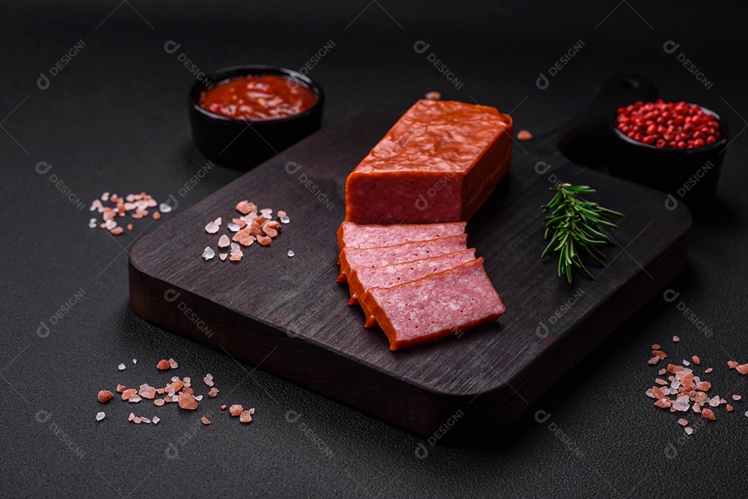 Delicioso salame de salsicha fresca com sal, tomate e especiarias sobre um fundo escuro de concreto