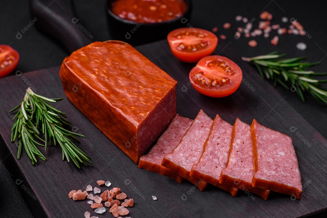 Delicioso salame de salsicha fresca com sal, tomate e especiarias sobre um fundo escuro de concreto