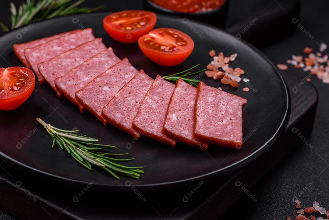 Delicioso salame de salsicha fresca com sal, tomate e especiarias sobre um fundo escuro de concreto