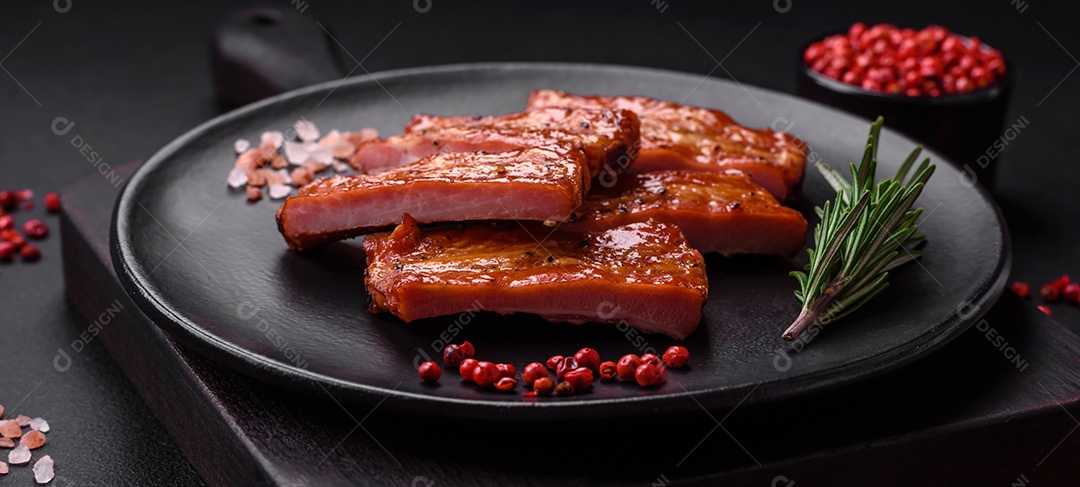 Costelas suculentas frescas grelhadas com sal, especiarias e ervas sobre um fundo escuro de concreto