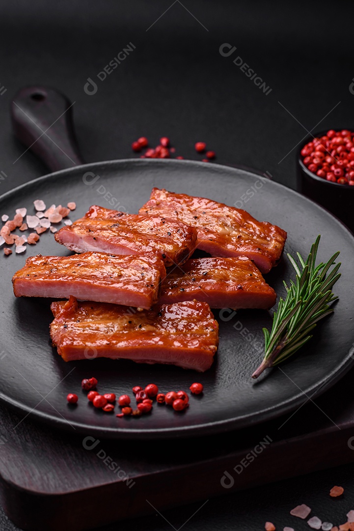 Costelas suculentas frescas grelhadas com sal, especiarias e ervas sobre um fundo escuro de concreto