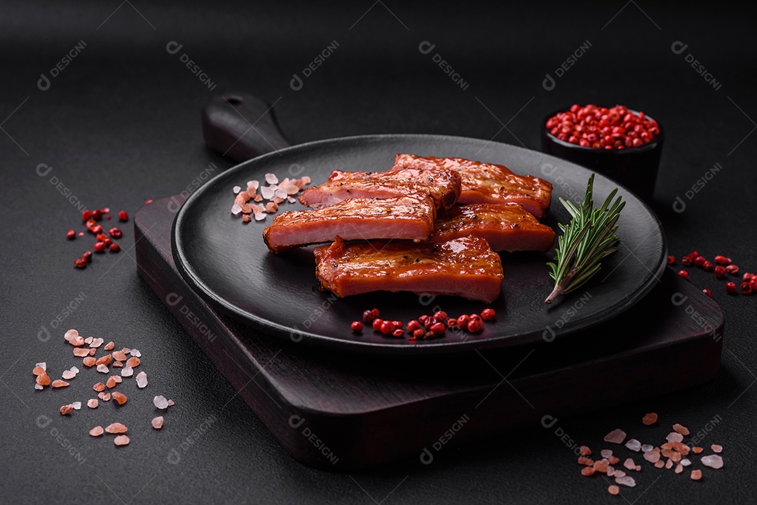 Costelas suculentas frescas grelhadas com sal, especiarias e ervas sobre um fundo escuro de concreto