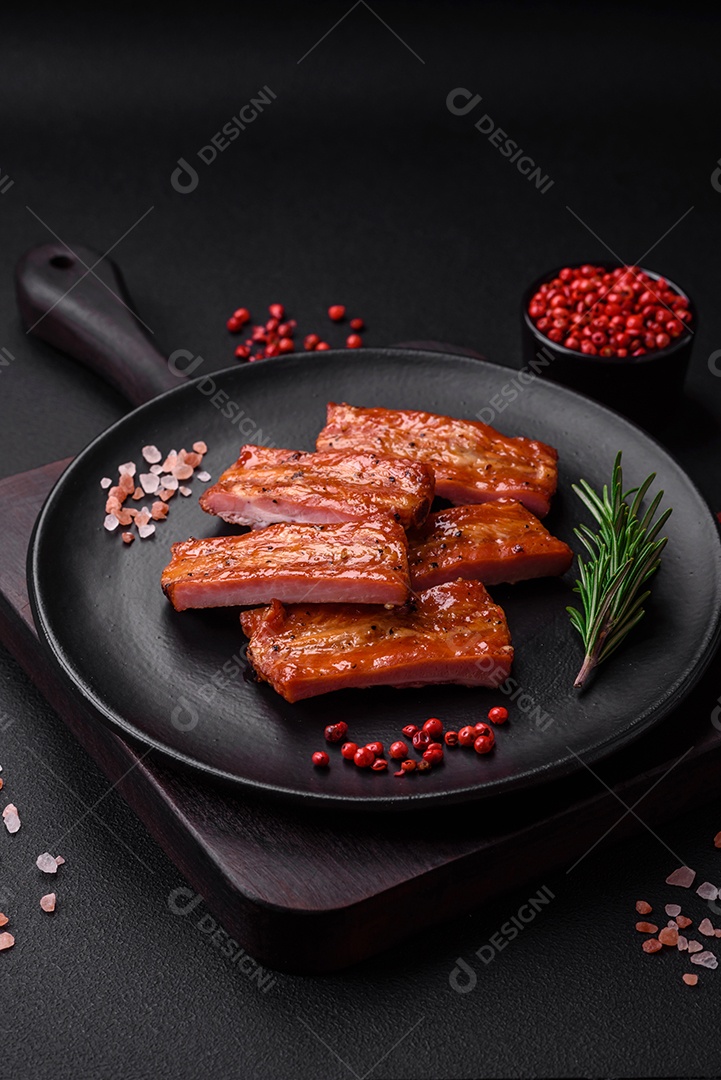 Costelas suculentas frescas grelhadas com sal, especiarias e ervas sobre um fundo escuro de concreto