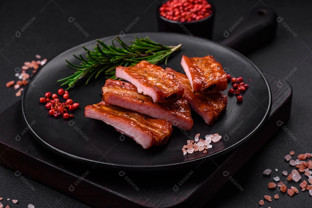 Costelas suculentas frescas grelhadas com sal, especiarias e ervas sobre um fundo escuro de concreto