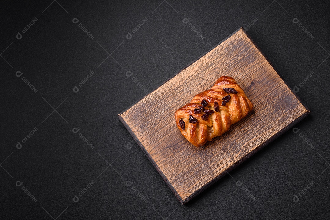 Delicioso pão de trança recém-assado com nozes e xarope sobre um fundo escuro de concreto
