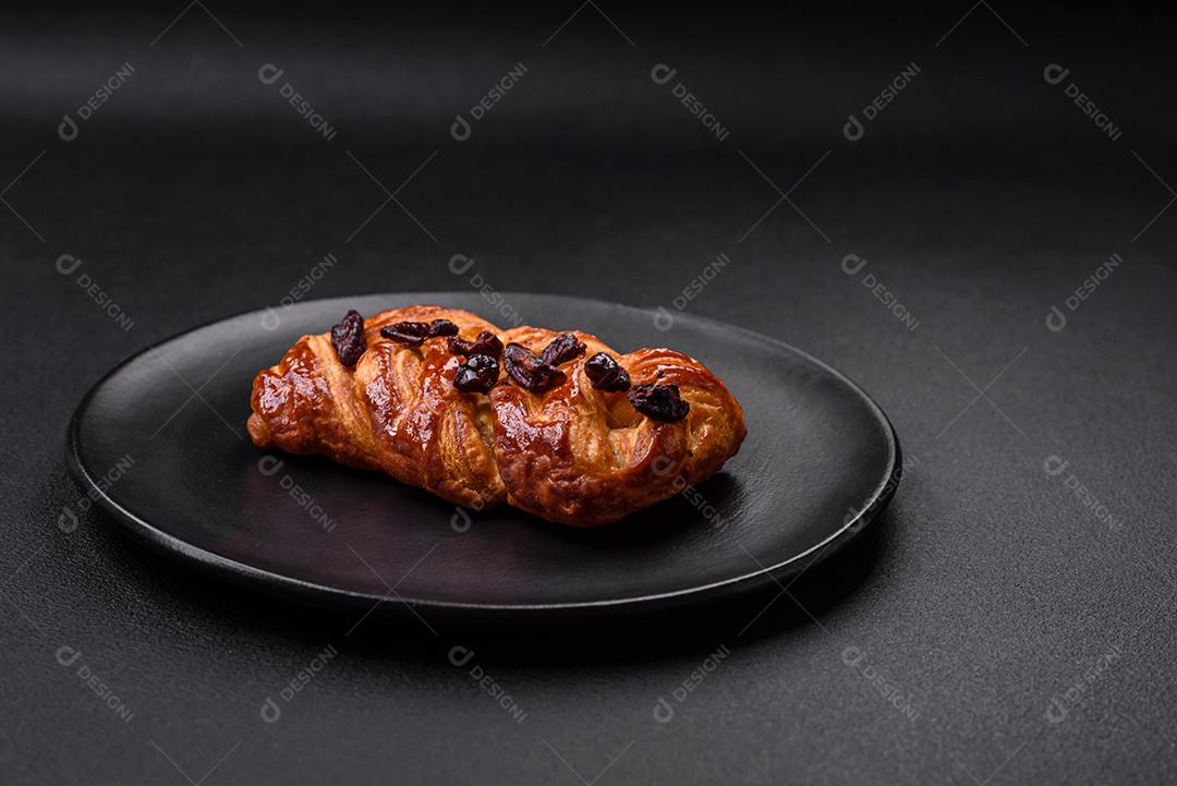 Delicioso pão de trança recém-assado com nozes e xarope sobre um fundo escuro de concreto