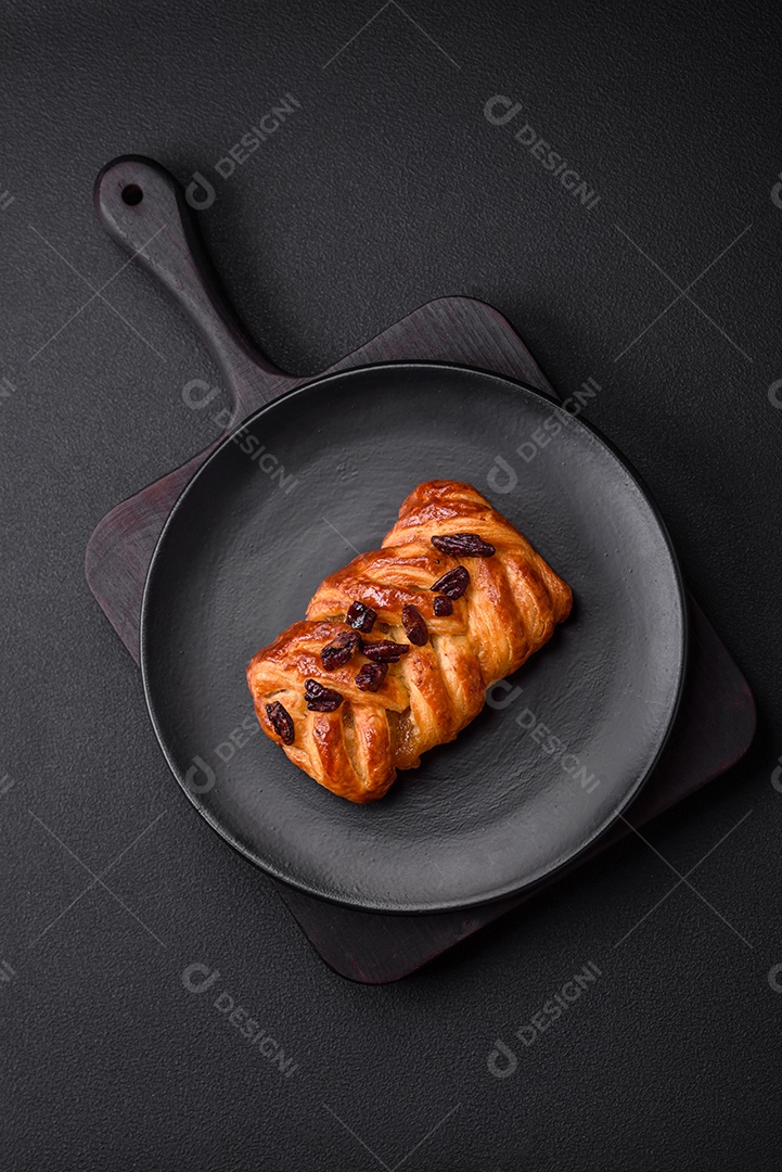 Delicioso pão de trança recém-assado com nozes e xarope sobre um fundo escuro de concreto