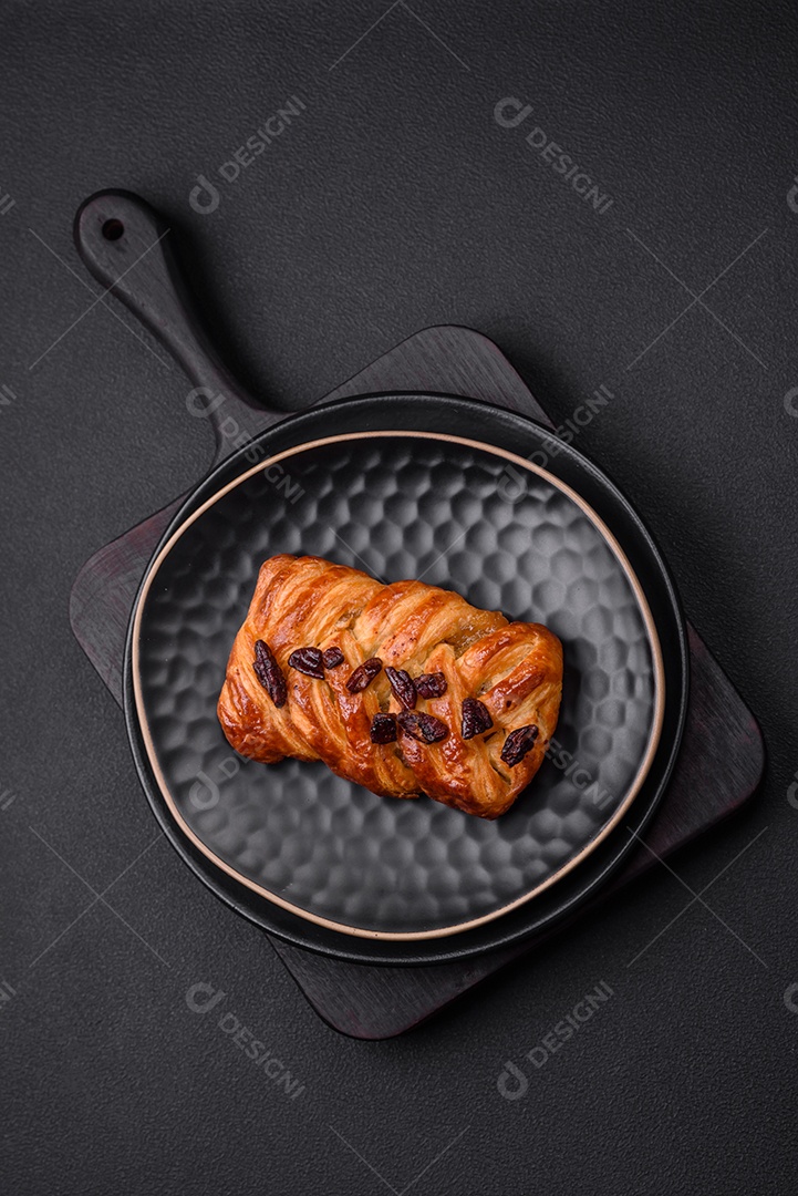 Delicioso pão de trança recém-assado com nozes e xarope sobre um fundo escuro de concreto