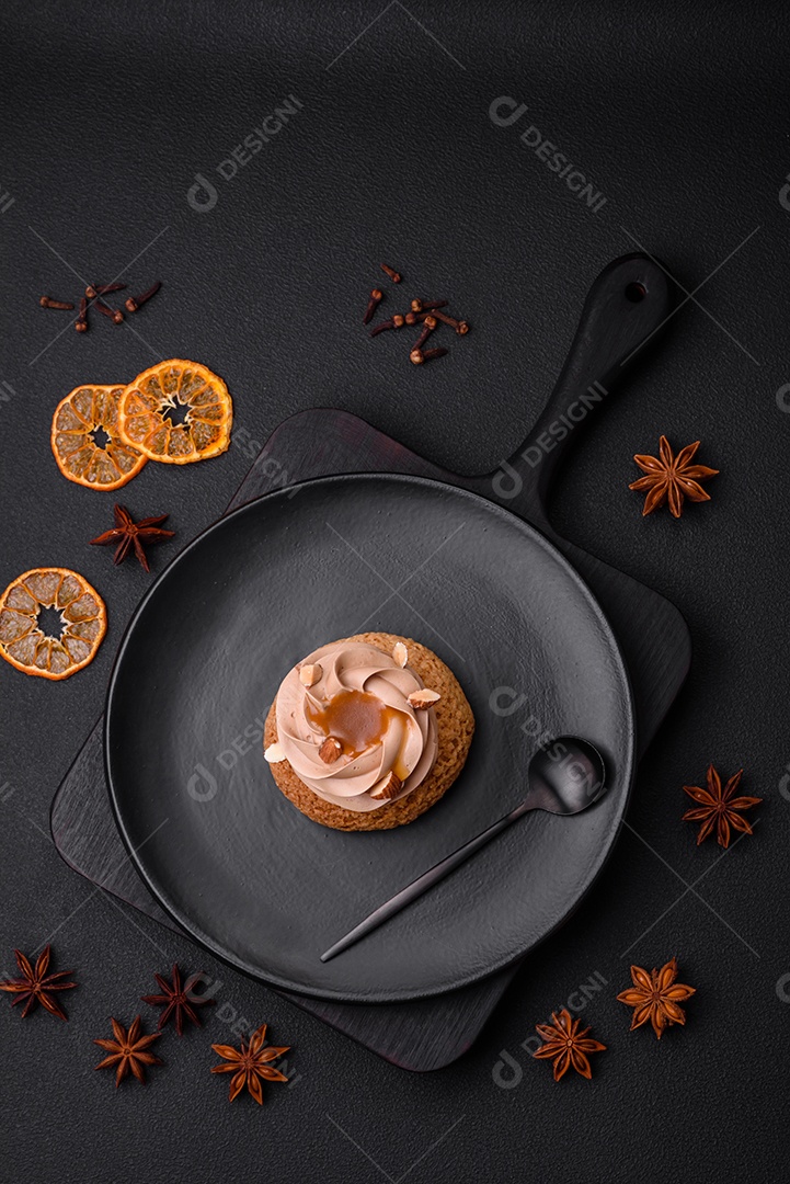 Delicioso bolo doce shu com creme e nozes sobre um fundo escuro de concreto
