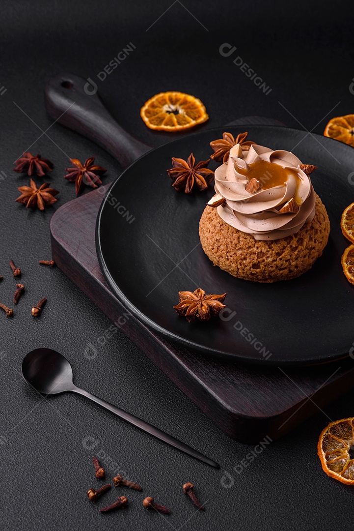 Delicioso bolo doce shu com creme e nozes sobre um fundo escuro de concreto