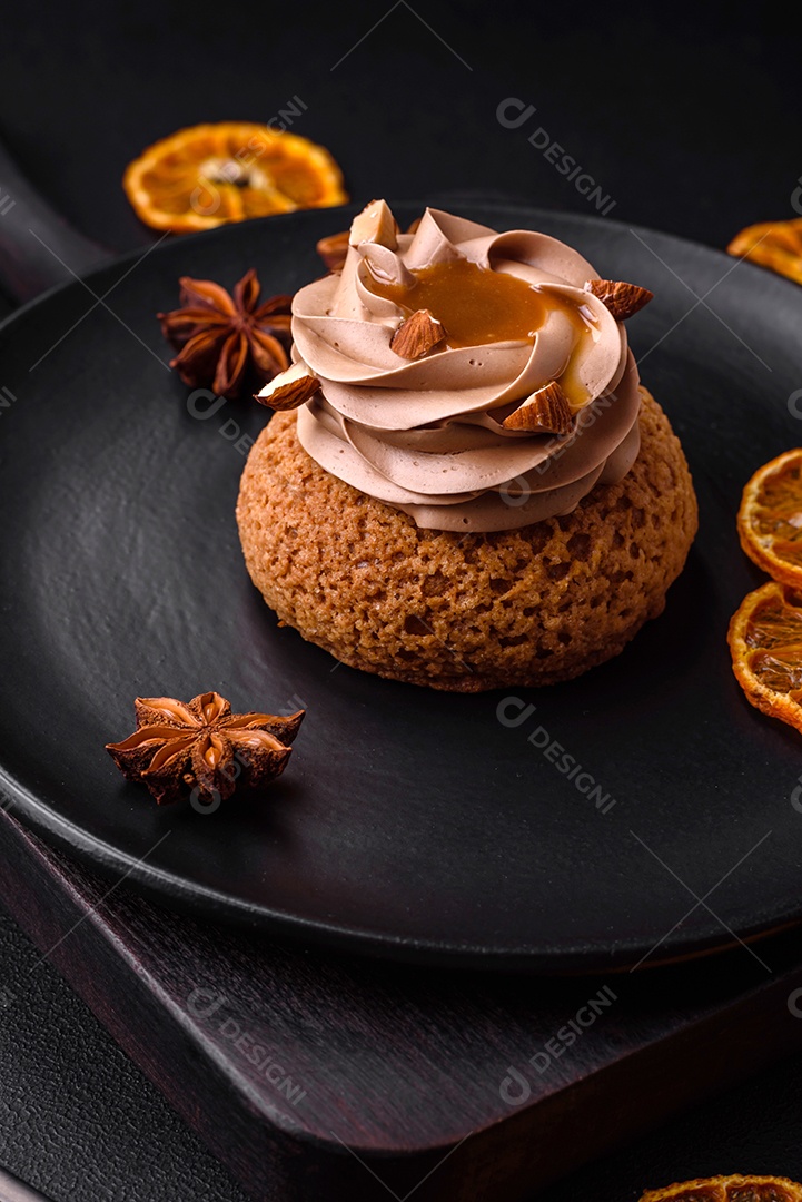 Delicioso bolo doce shu com creme e nozes sobre um fundo escuro de concreto